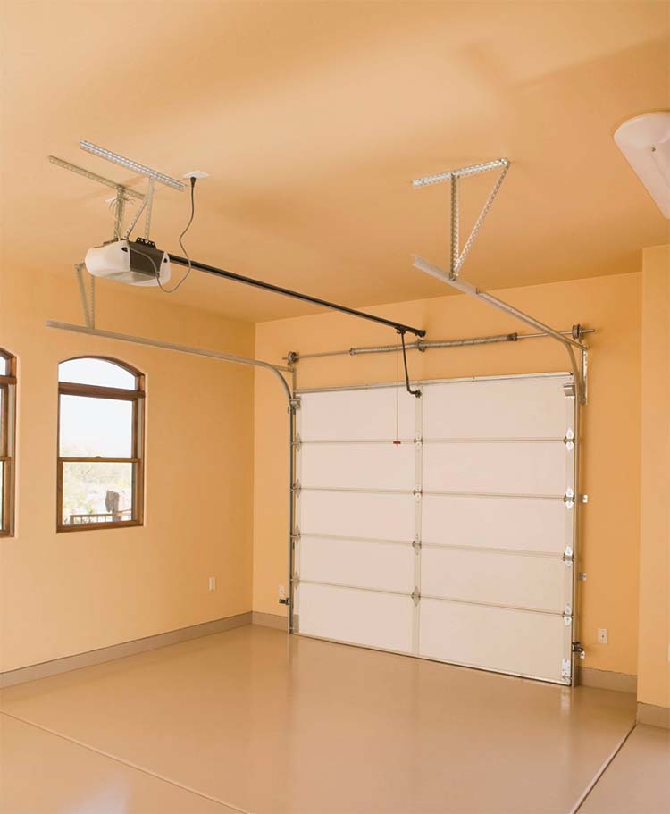 A garage featuring a ceiling fan and overhead lights, providing illumination and ventilation for the space.